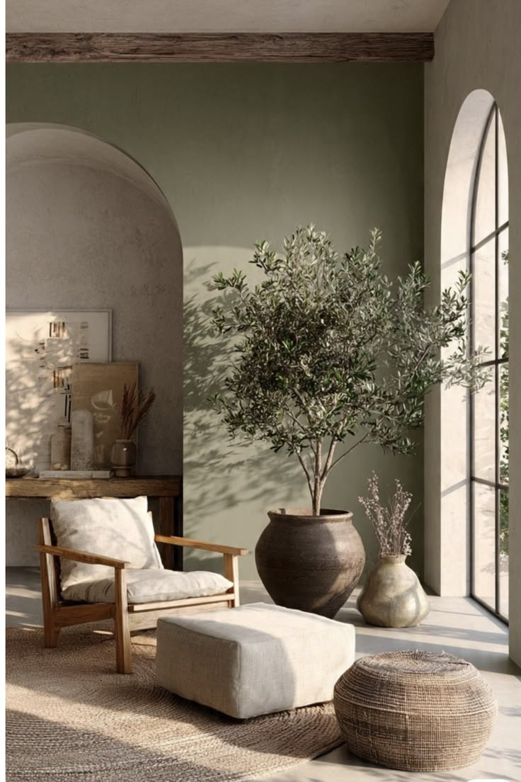 A sunlit living room with an olive tree, arched window and linen armchair.